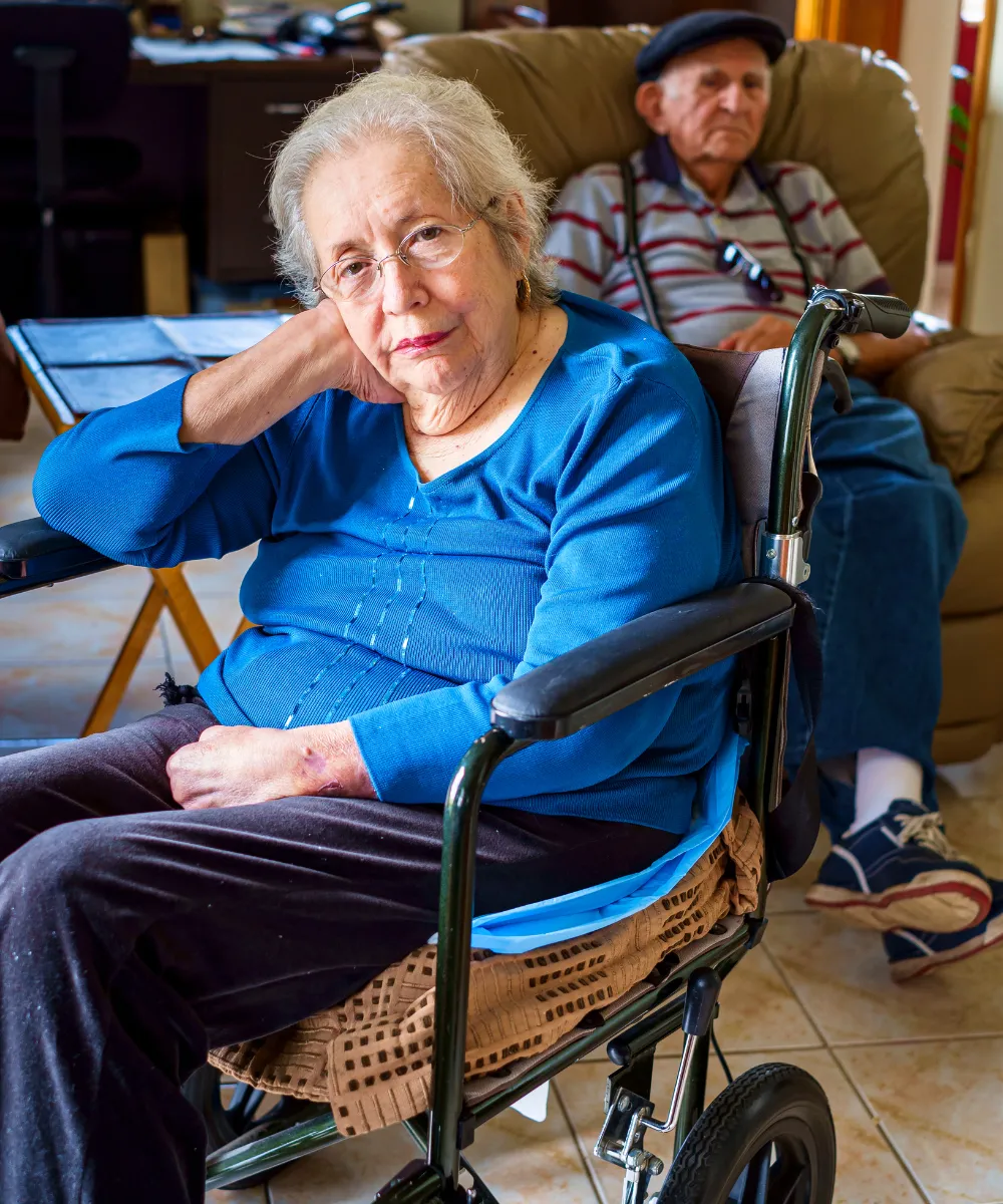 An adult daughter and her elderly mother walking through the garden of a bright, welcoming senior living community during a facility tour